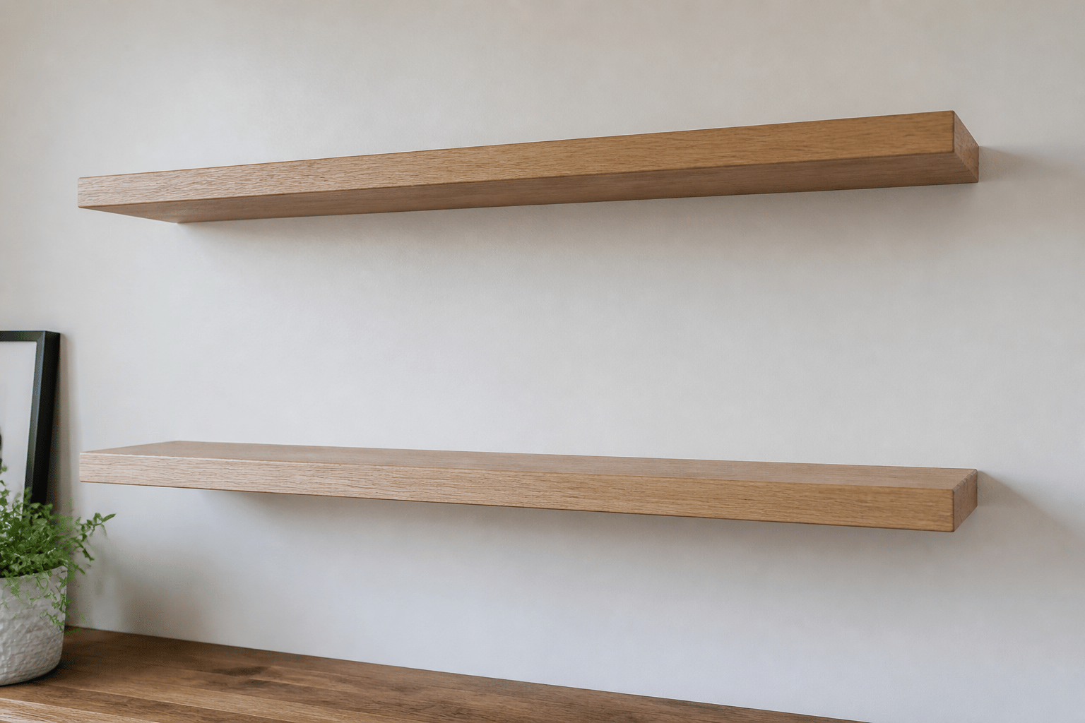 Pair of light oak floating shelves on a white wall